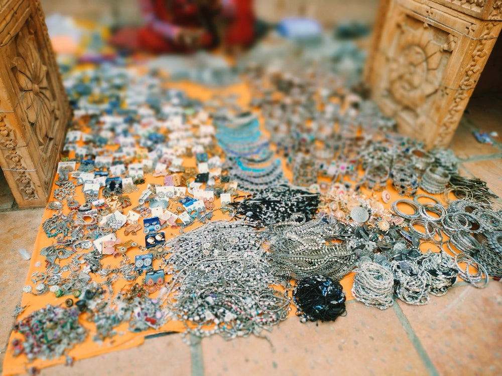 Handmade silver jewellery laid out on cloth at a market stall